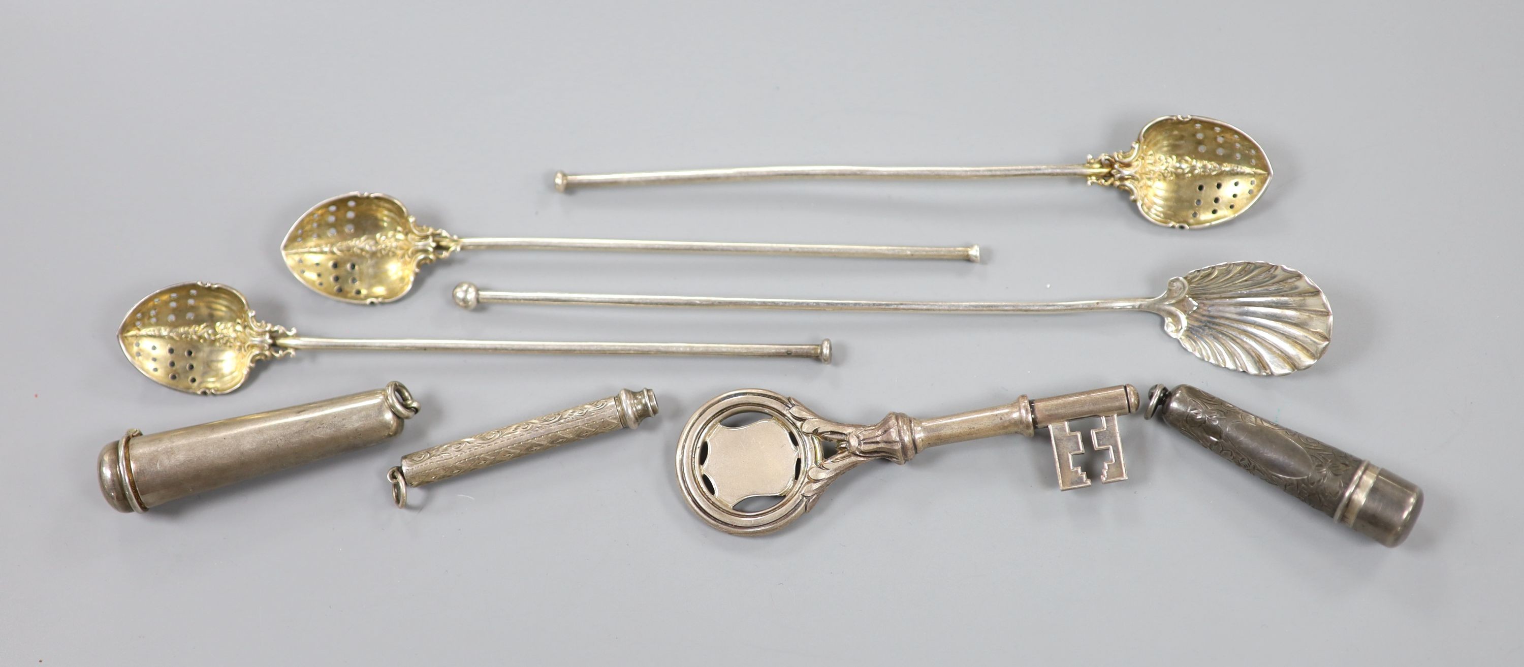 A 1939's silver presentation key, London, 1935, 10.2cm, a white metal cheroot holder case and a similar silver case, an engraved white metal cased propelling pencil and four silver long hollow spoons, with pierced bowls.